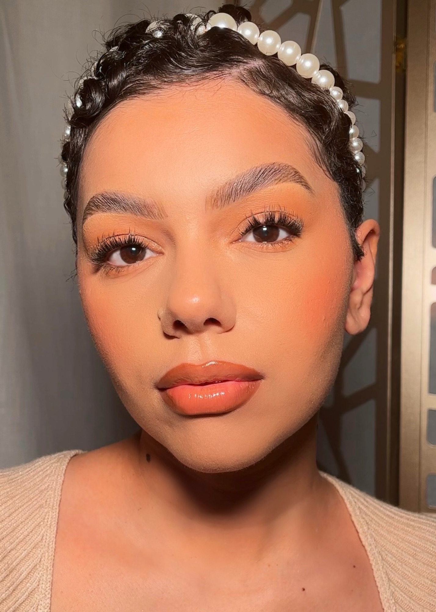 Peachy soft glam makeup look on light medium skin with a nude peachy lip from Fenty Beauty.